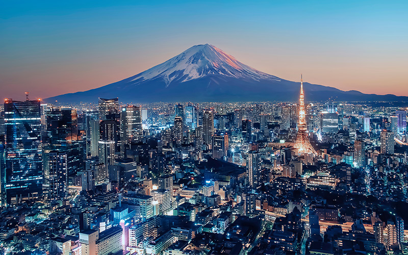 Mount Fuji behind skyline of Toyoko at sunset