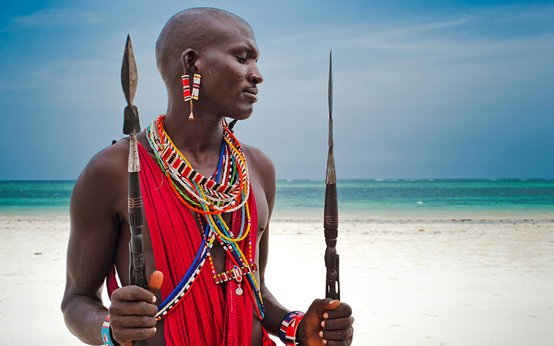 Maasai warrior wearing traditional dress, Diani Beach, Africa.