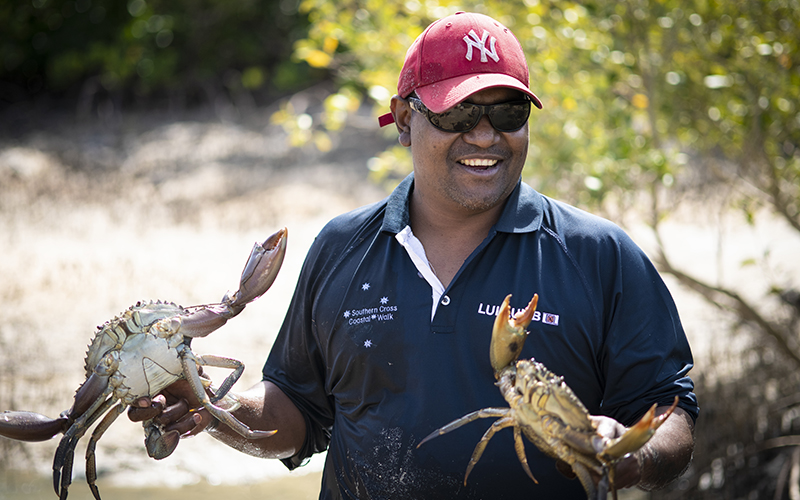 Tour guide holding a crab in each hand