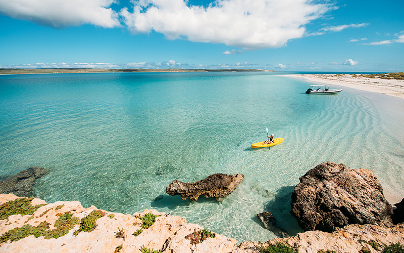 Person kayaking in crystal clear waters at Dirk Kartog Island