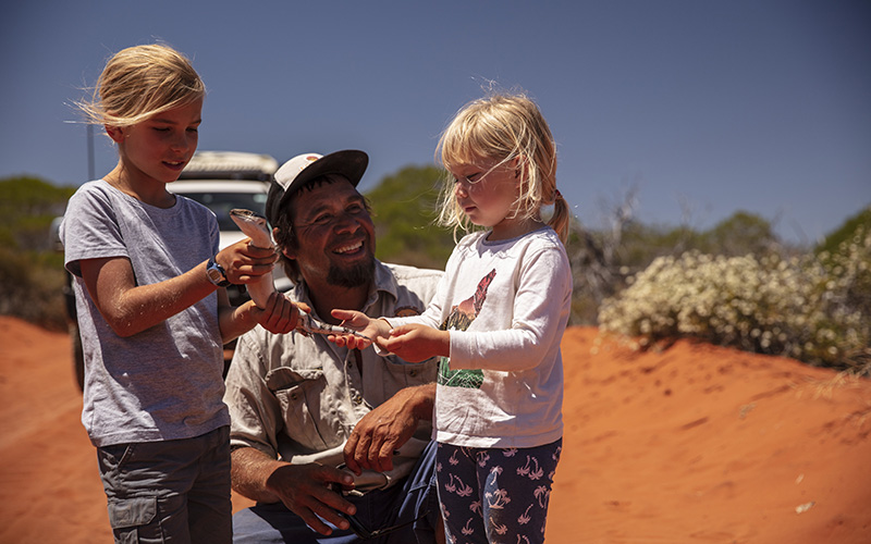 Children holding reptile with tour guide from Wula Gura Nyinda Eco Adventures, Shark Bay